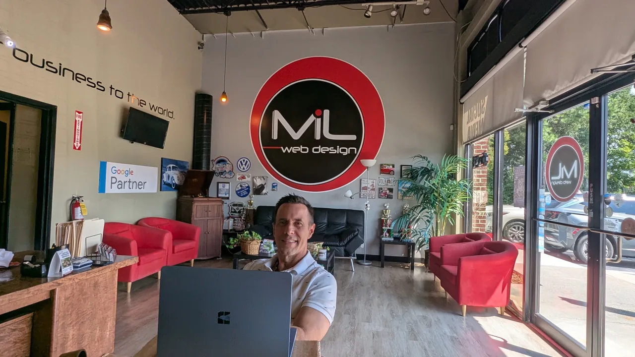 Make It Loud owner John working in the company lobby beneath the Make It Loud logo