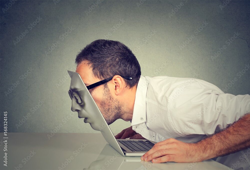 Man in white shirt closely examines a laptop screen, demonstrating digital marketing analysis for Make It Loud Digital Marketing.